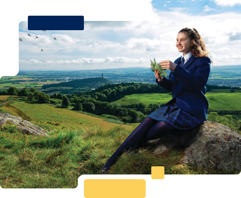 Girl sitting on rock by scenic landscape